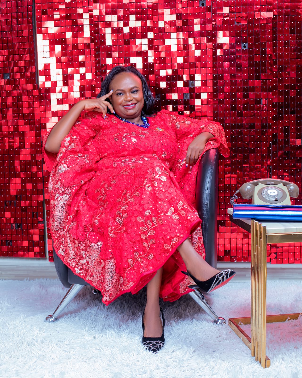 Jennifer Kianga seated in a red gown